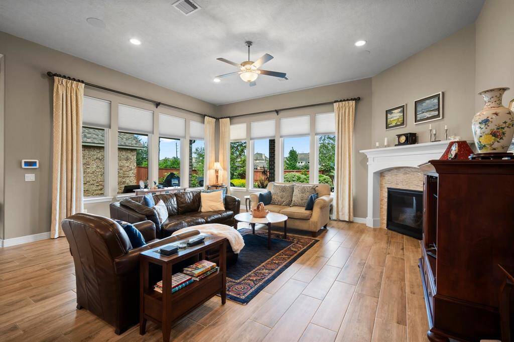 Relax and unwind in this warm and welcoming Family Room, where eight sunny windows frame breathtaking views of the spacious backyard, covered porch, and pool/spa.