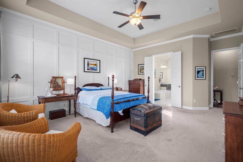 The inviting Owner’s Suite is a private retreat designed for ultimate relaxation. A stunning tray ceiling with crown molding and lighted ceiling fan adds architectural elegance, while lush carpeting and a stylish wall of wood detailing complete the refined look. Spacious, serene, and beautifully appointed — the perfect escape at the end of the day.
