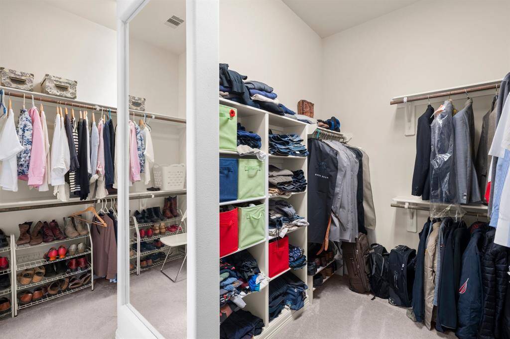 Say goodbye to storage struggles in this expansive walk-in closet, thoughtfully designed to meet all your wardrobe needs. A custom center peninsula with built-in shelving and a full-length mirror adds both style and function, while abundant hanging space along the perimeter ensures everything has its place. This well-appointed closet offers the perfect blend of luxury and organization.