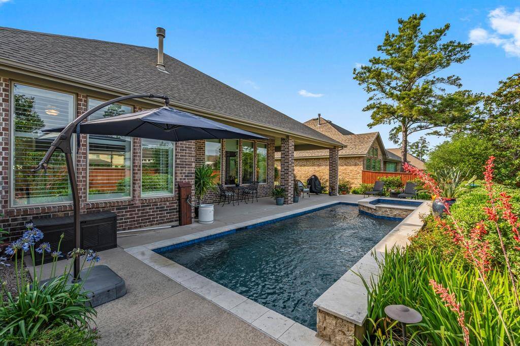 The heated pool with a cascading rock waterfall and spa makes every day feel like a vacation, while lush tropical landscaping adds to the paradise vibe.