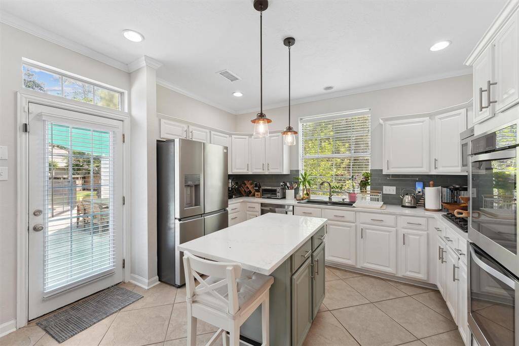 Kitchen includes stainless steel appliances.