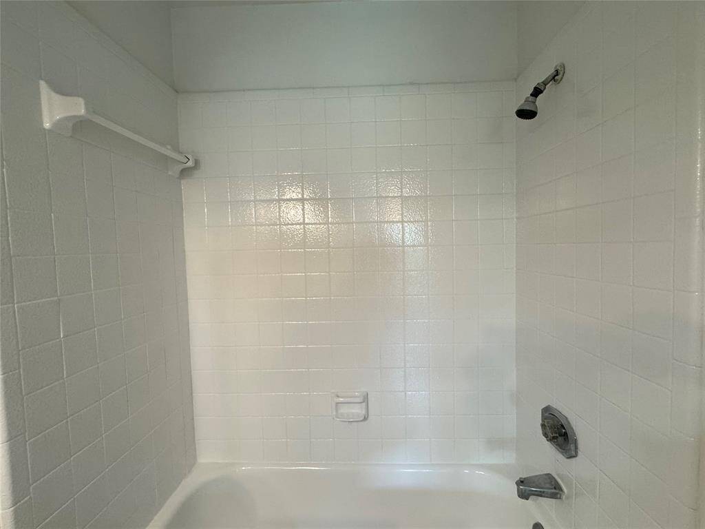 Hallway leads to secondary bathroom, laundry in middle, bedroom on right