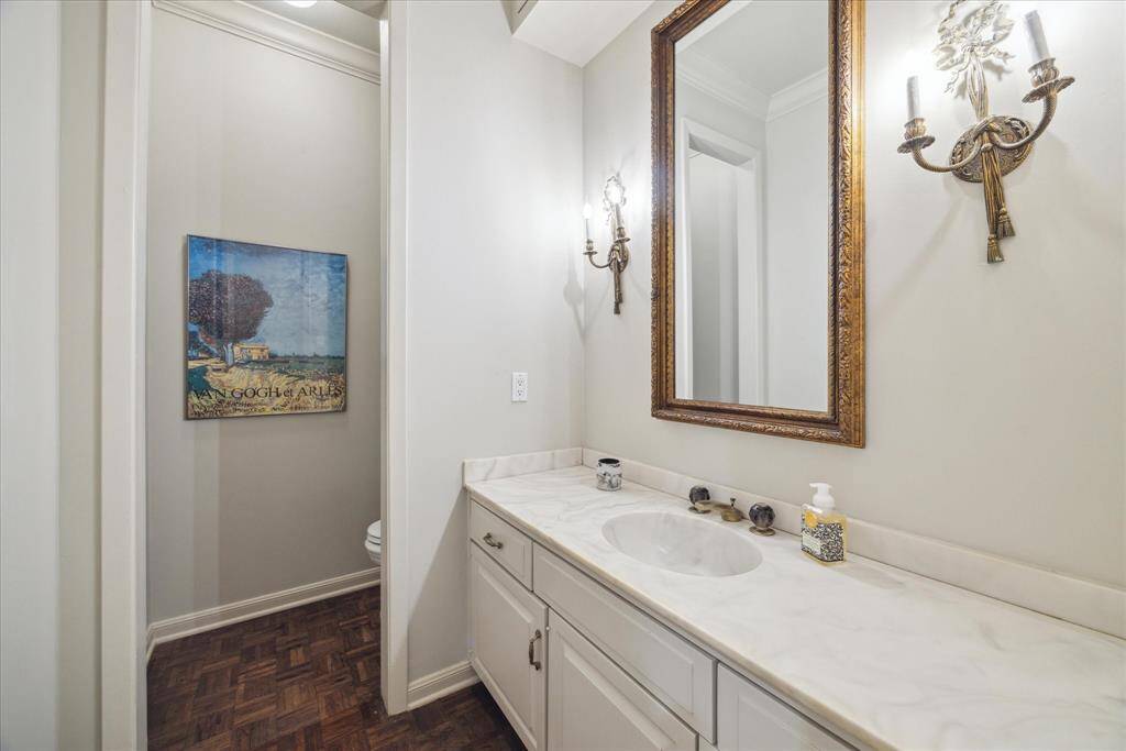 The main floor powder room is highlighted with antique sconces and parquet wood floors.