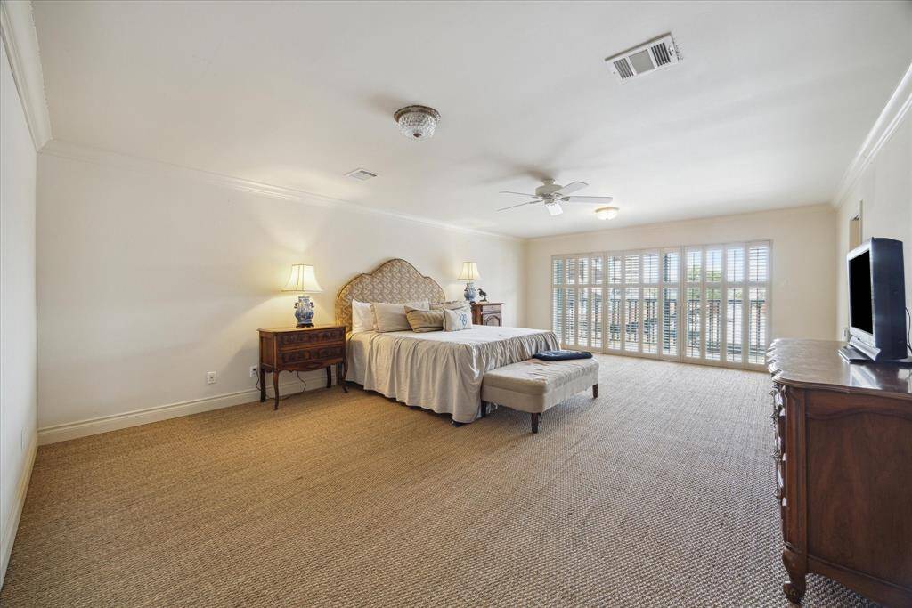 Wow!  Look at the size of this primary suite!  Gorgeous seagrass flooring sets the stage for this owner's retreat. Sunlight filters through the shuttered sliding doors opening to a balcony; a perfect setting for your morning coffee.