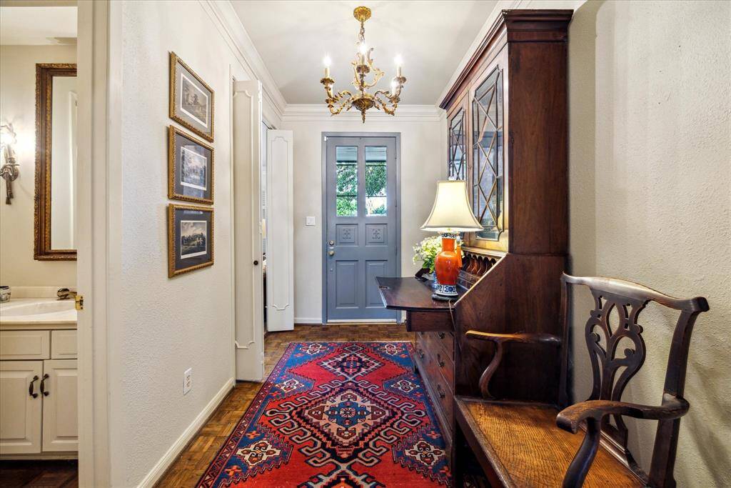 The entry foyer features an antique chandelier and parquet wood floors. As one enters the home the formal living room (could be a study) is on the right. The guest bath is located at the end of the entry foyer.
