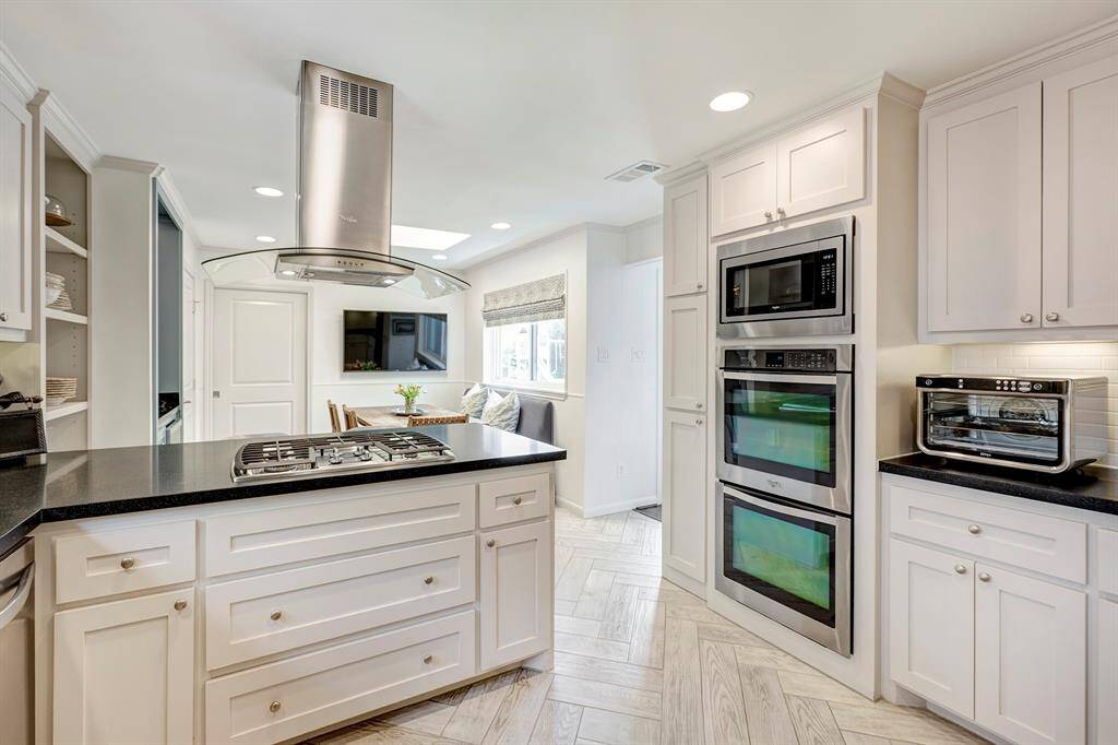 This well-equipped kitchen features double ovens, ample countertop space, and neutral tones that create a bright, inviting atmosphere.