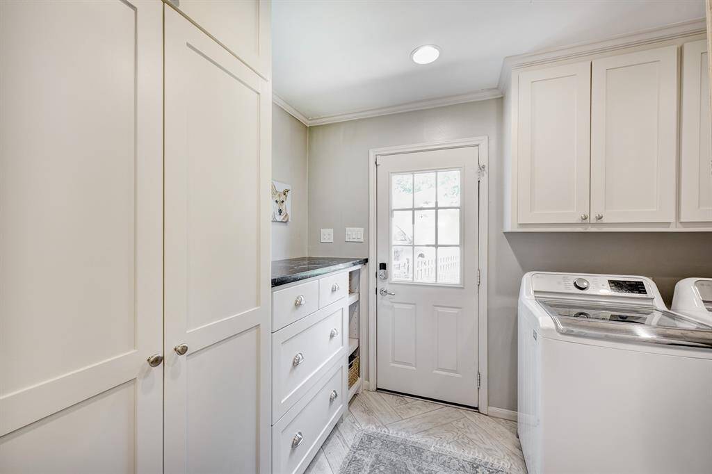 Laundry room with abundant built-in storage, folding countertop, plus a door that leads directly to the backyard for added convenience.