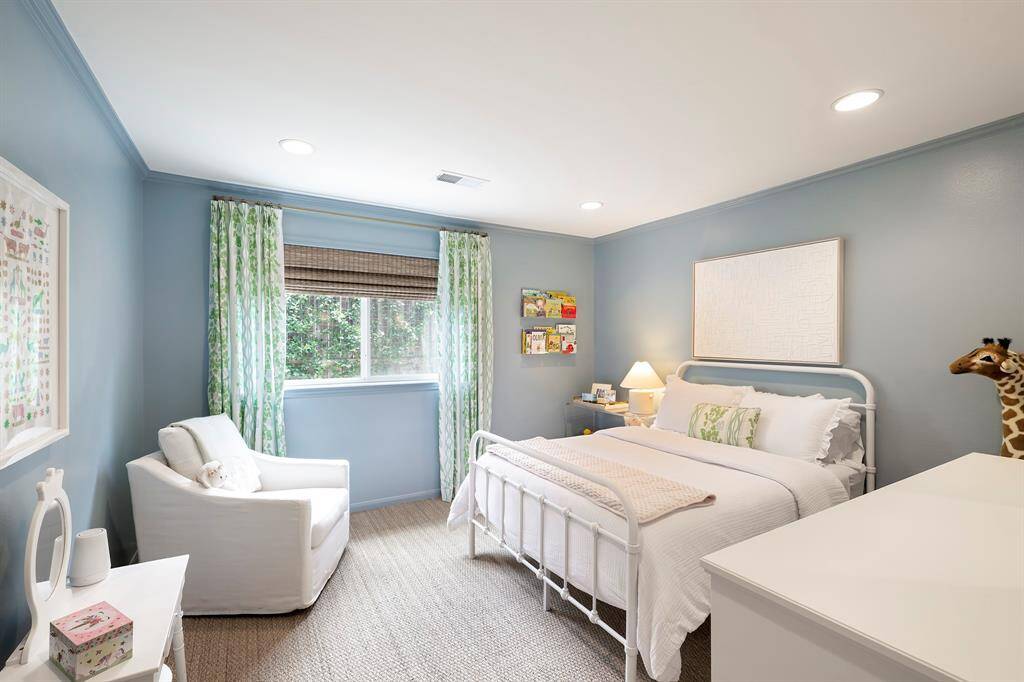 A view of the other secondary bedroom with a window that fills the room with natural light.
