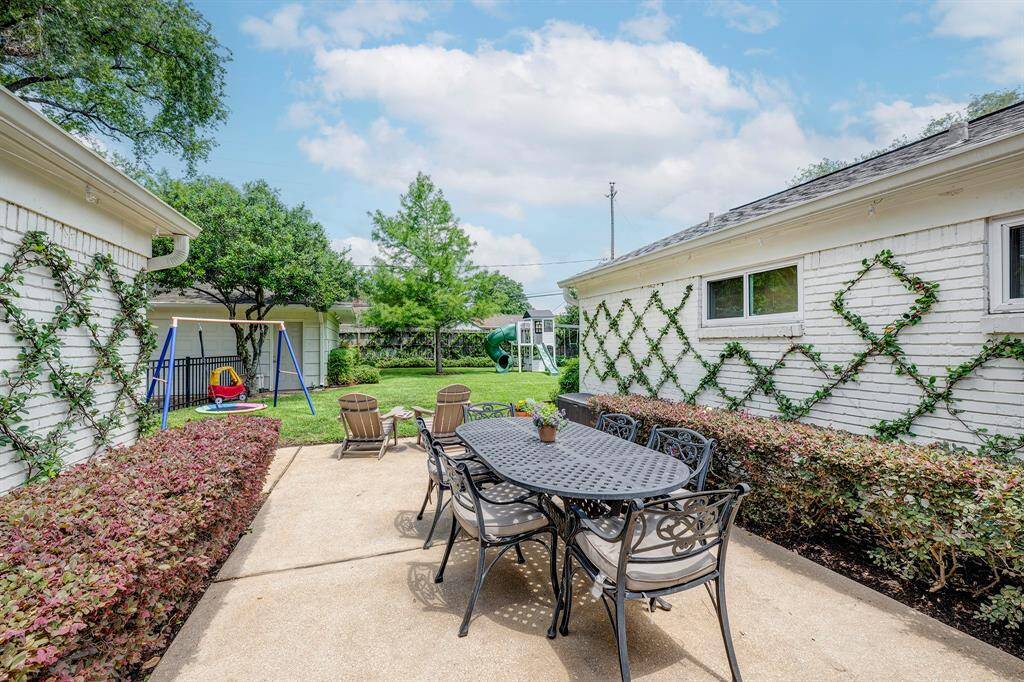 Spacious patio with room for a dining table and seating area offers a view of the backyard and garage.