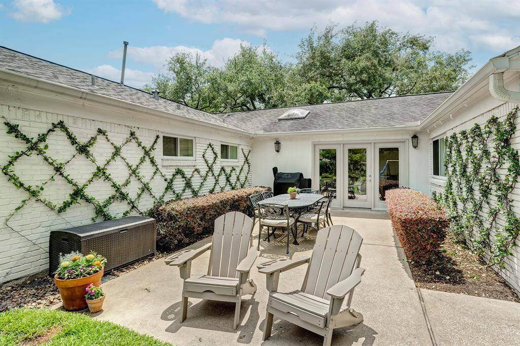 Looking from the patio towards the house. This space is great for entertaining or grilling and is surrounded by shrubs and jasmine.