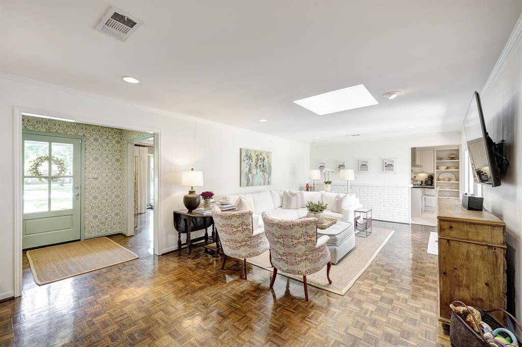 This flexible front room, just off the dining room, offers a view of the front yard and features built-in shelving, cabinetry, and a daybed. The gold light fixture is excluded.