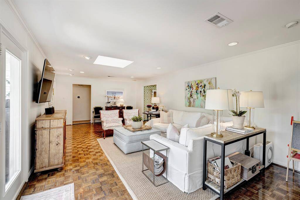 Another angle of the family room showcasing built-in shelves and cabinet. French doors open to the patio and backyard, offering easy outdoor access.