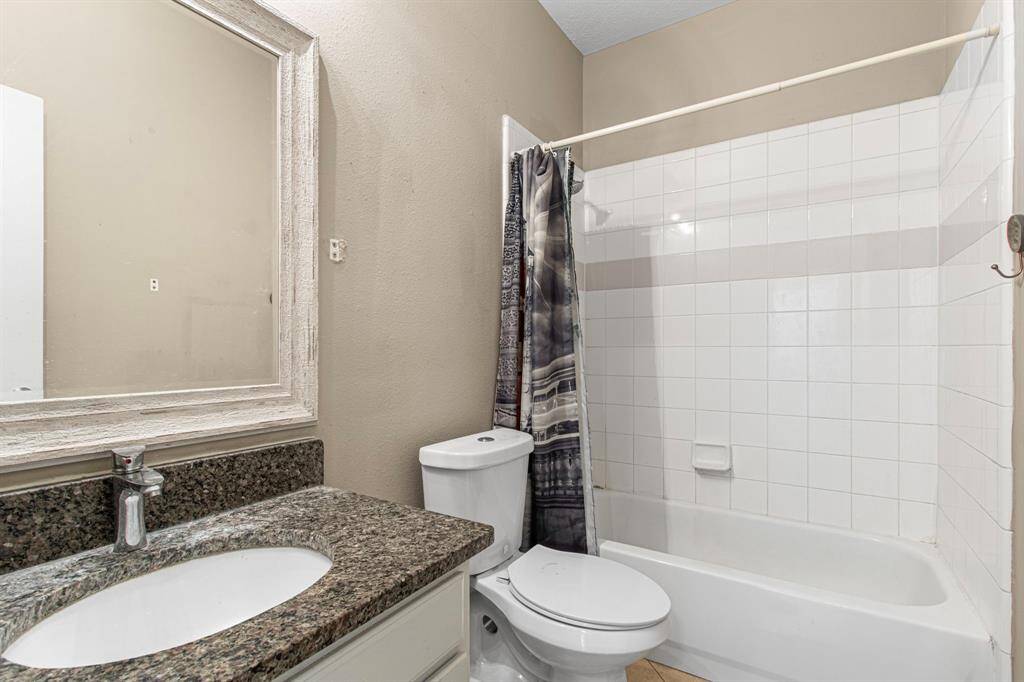 The secondary bathroom features granite countertops and an updated mirror.