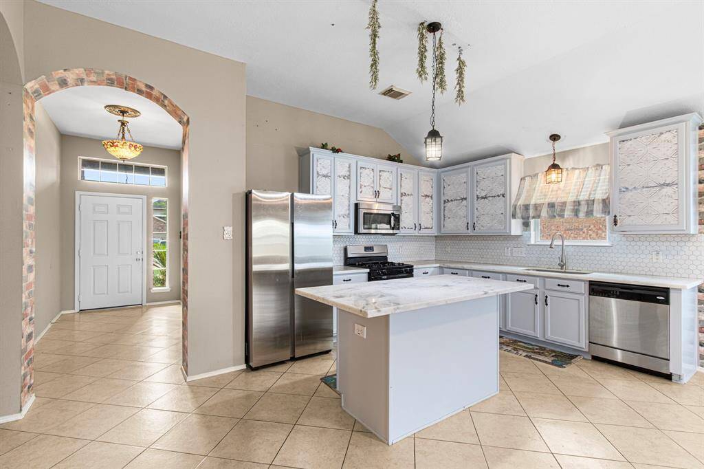 Marble countertops are a top-tier upgrade, giving the cottage-style kitchen an elevated aesthetic.