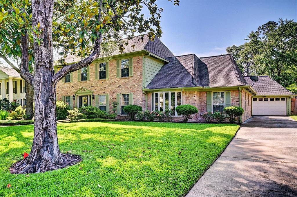 This charming two-story brick home features a well-maintained front yard with lush grass and mature trees. It has a classic design with large windows, green shutters, and a welcoming driveway leading to a detached garage. Ideal for families seeking a picturesque and serene neighborhood setting.