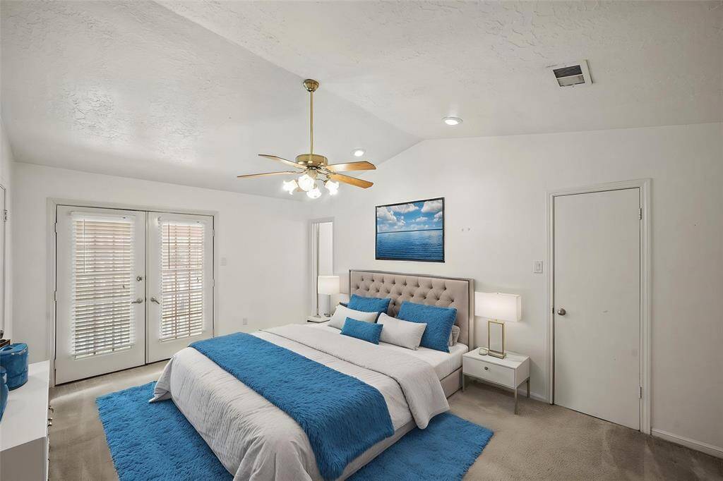 The upstairs primary bedroom features elegant double French doors that open to your own private patio, creating a peaceful retreat to unwind and enjoy the outdoors. - virtually staged