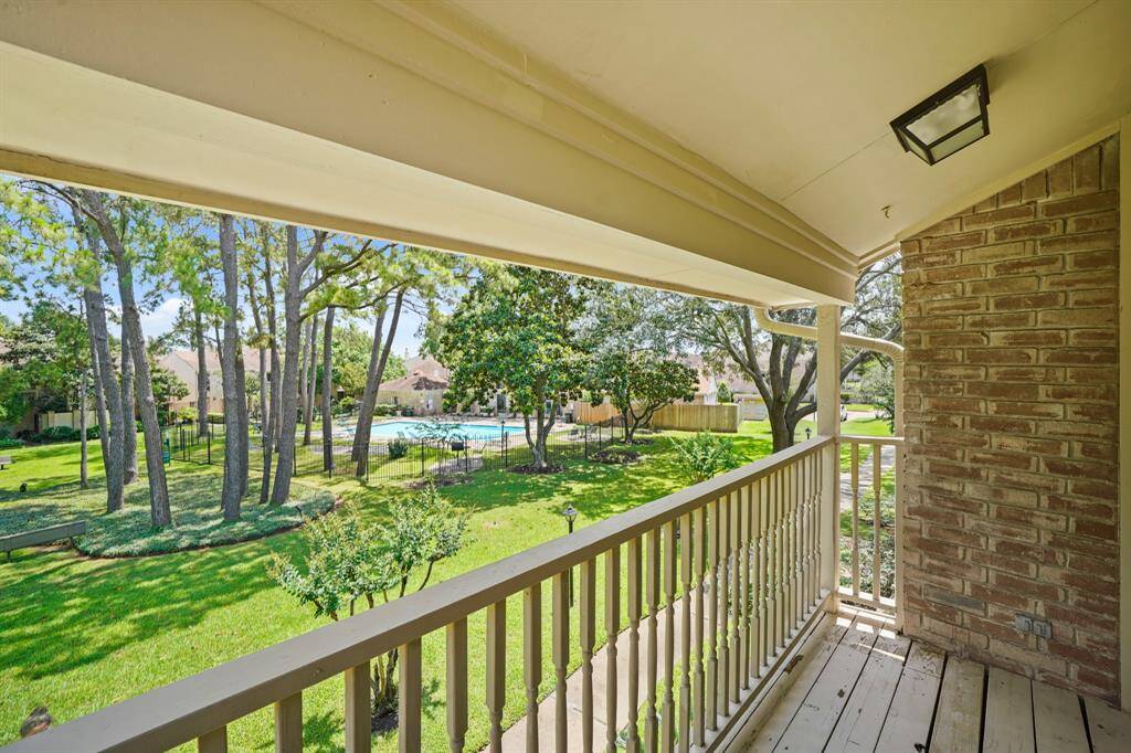 The private patio offers a serene escape, with a beautiful view of the lush green space and sparkling pool, providing the perfect spot to relax and enjoy the peaceful surroundings.