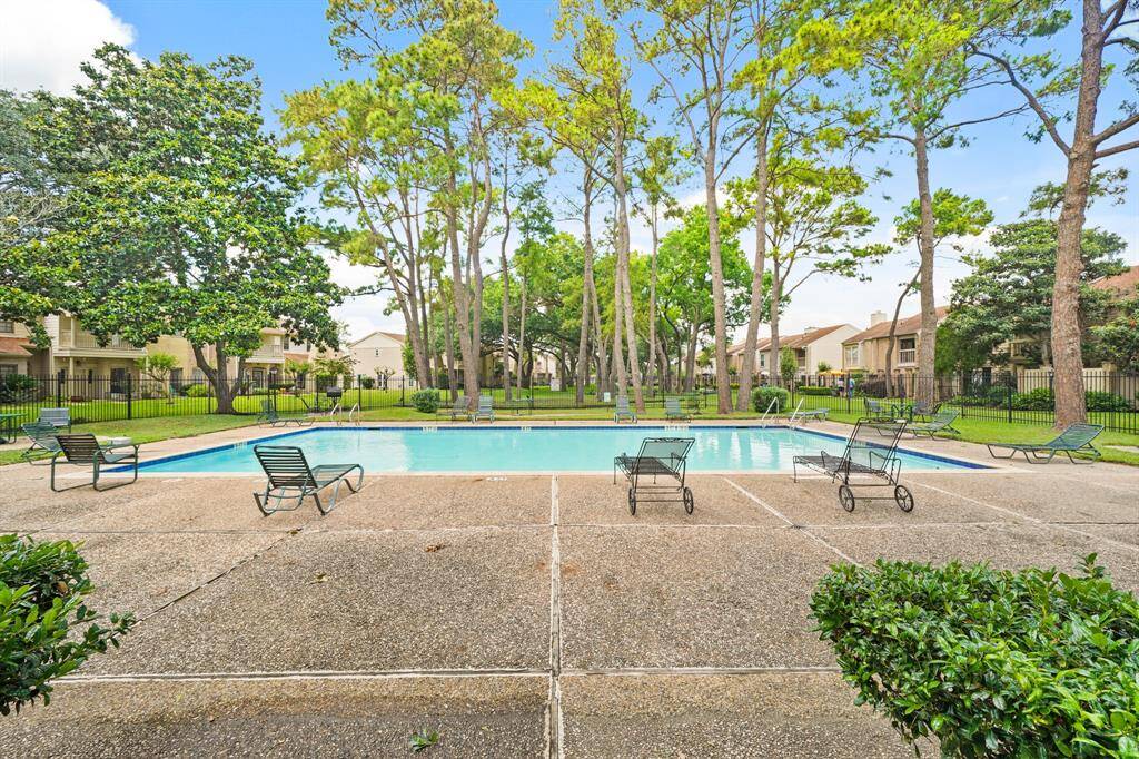 The pool is beautifully surrounded by lush, mature trees, creating a serene and private oasis perfect for relaxation and enjoying the outdoors.