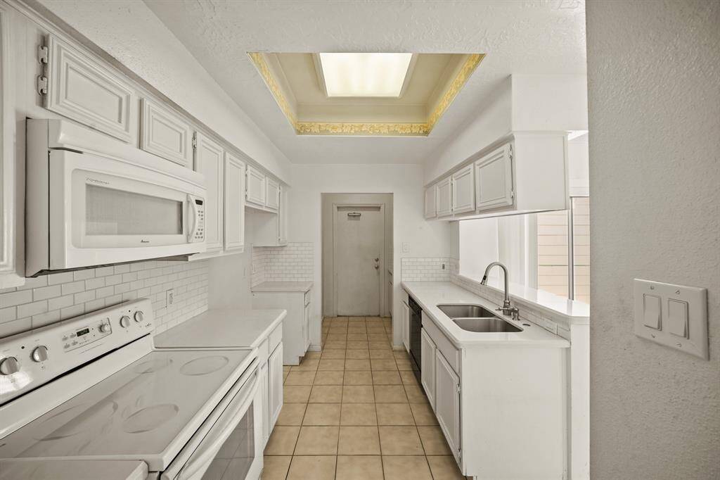 Your chef inspired kitchen awaits! Features include corian countertops paired with a coordinating tile backsplash, crisp white cabinets, ample lighting, and breakfast bar seating.