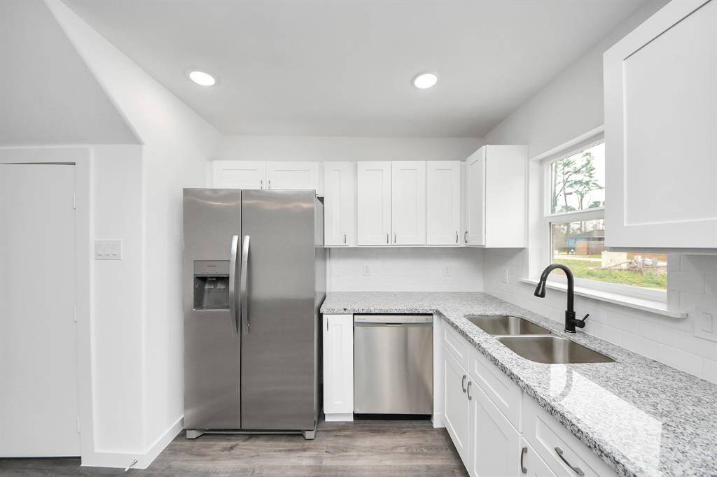 The kitchen has a stainless steel sink and window above with plenty of natural light.