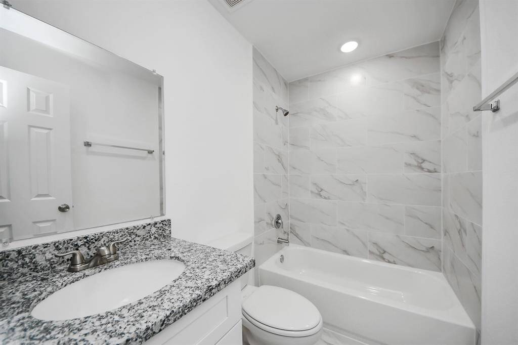 The primary bathroom features a tub and shower combo with tile surround.