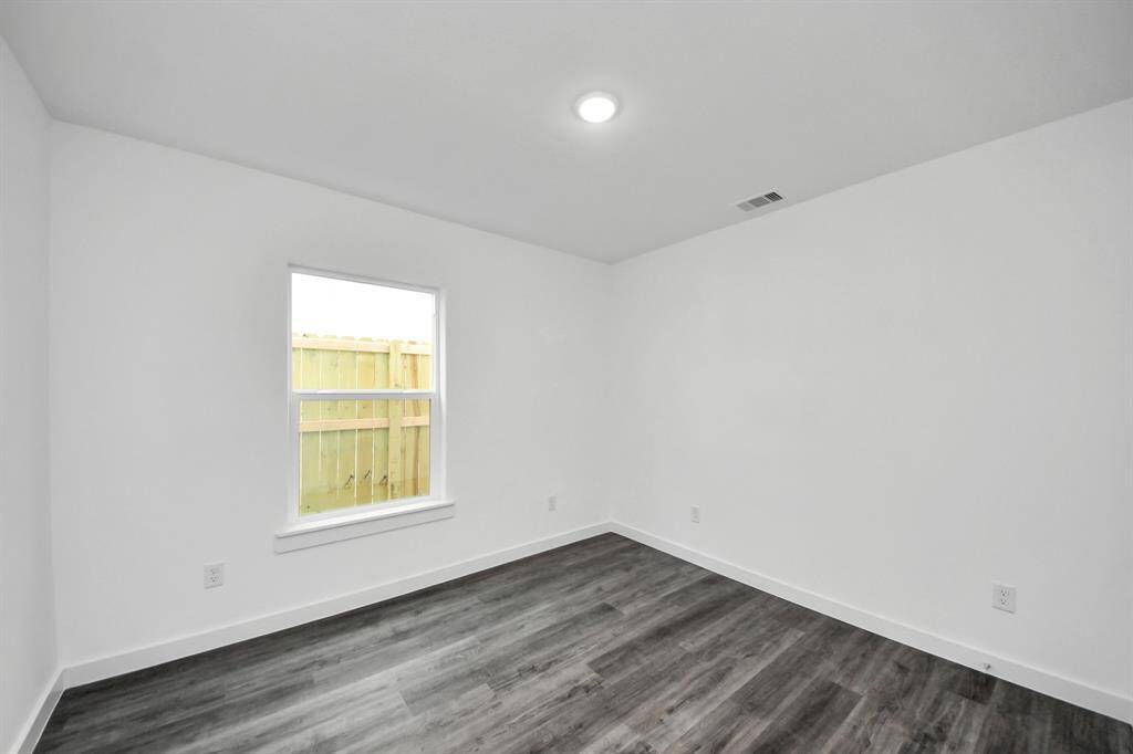 Secondary bedroom features recessed lighting and a large window.