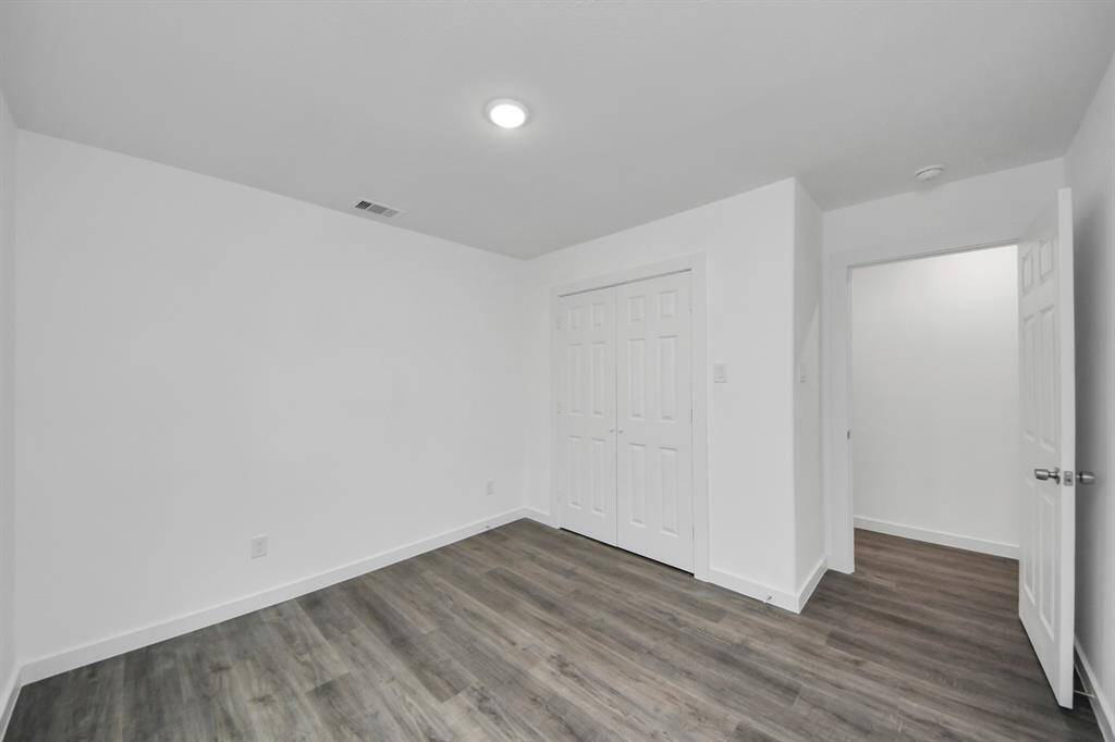 Secondary bedroom features recessed lighting and a large window.