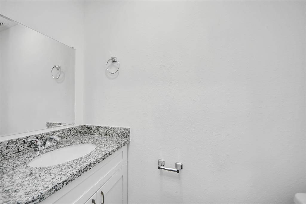 Third bathroom has white cabinets.
