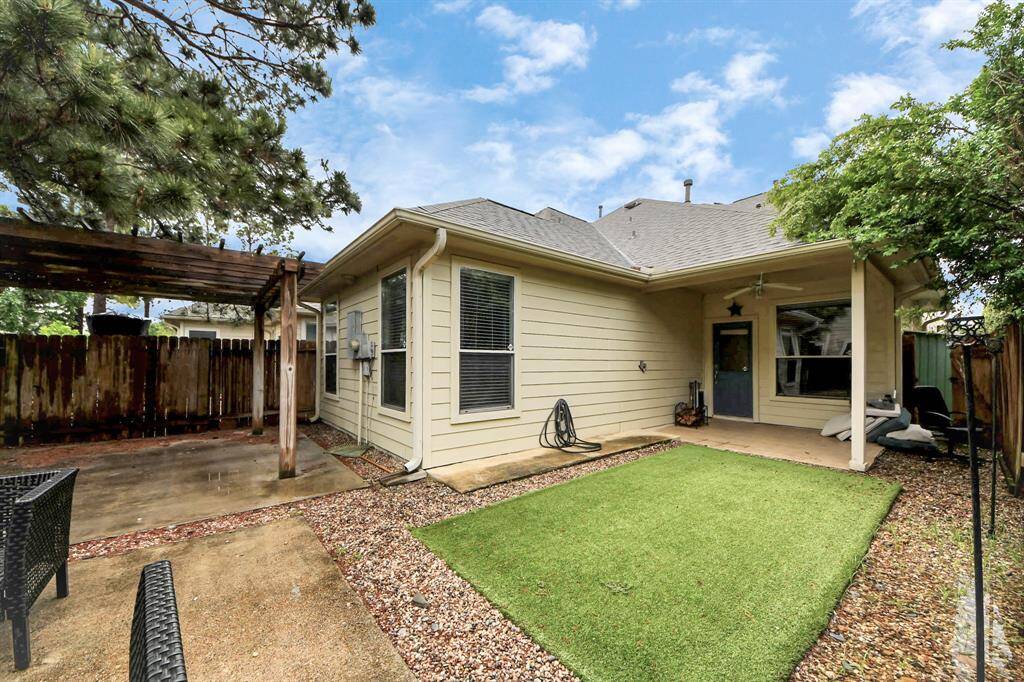 Private backyard with a spacious covered patio, perfect for outdoor dining and relaxation.