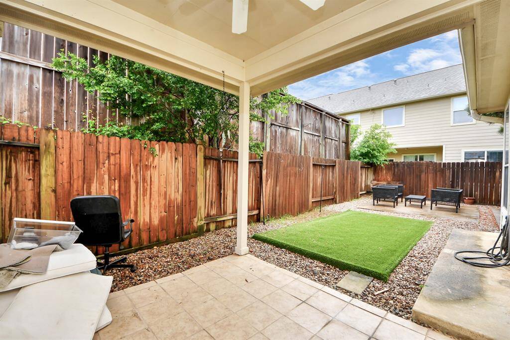 Cozy covered patio with a ceiling fan, providing a cool and comfortable space for outdoor relaxation.