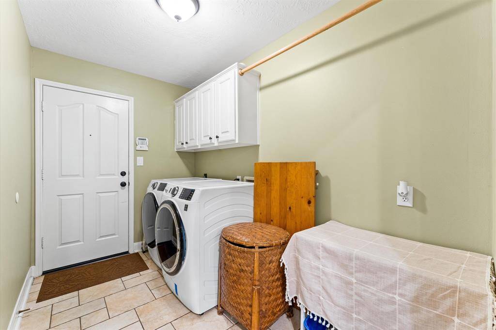 Spacious utility room with ample storage and space for a secondary fridge.