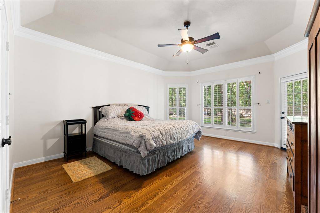 Expansive primary bedroom with direct access to a covered patio and backyard.