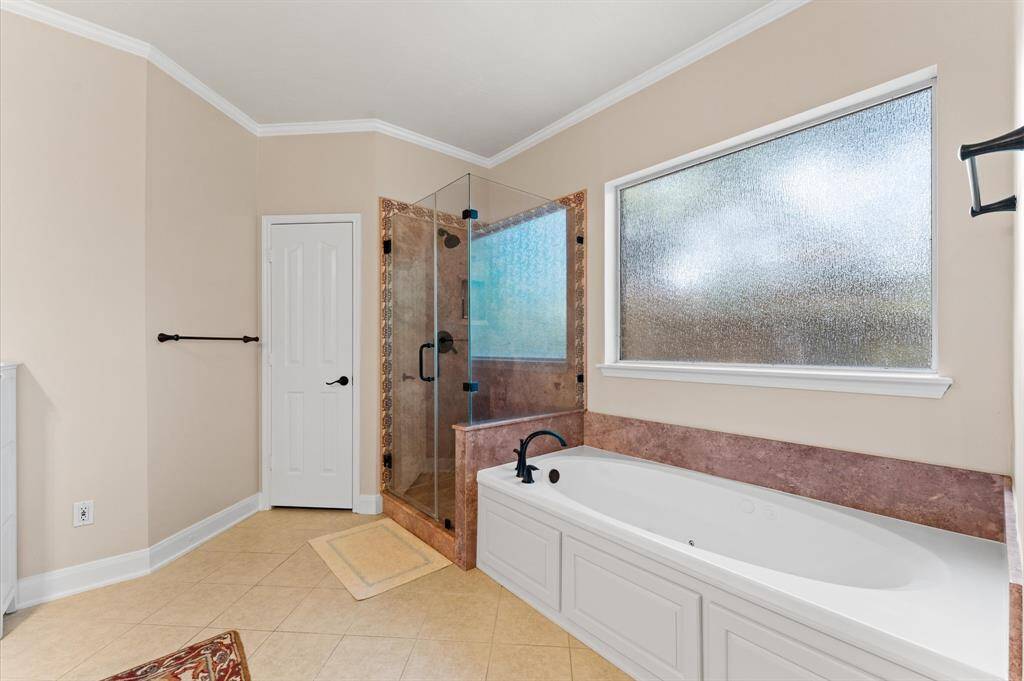 Indulge in luxury with a spacious jetted tub and sleek frameless shower.