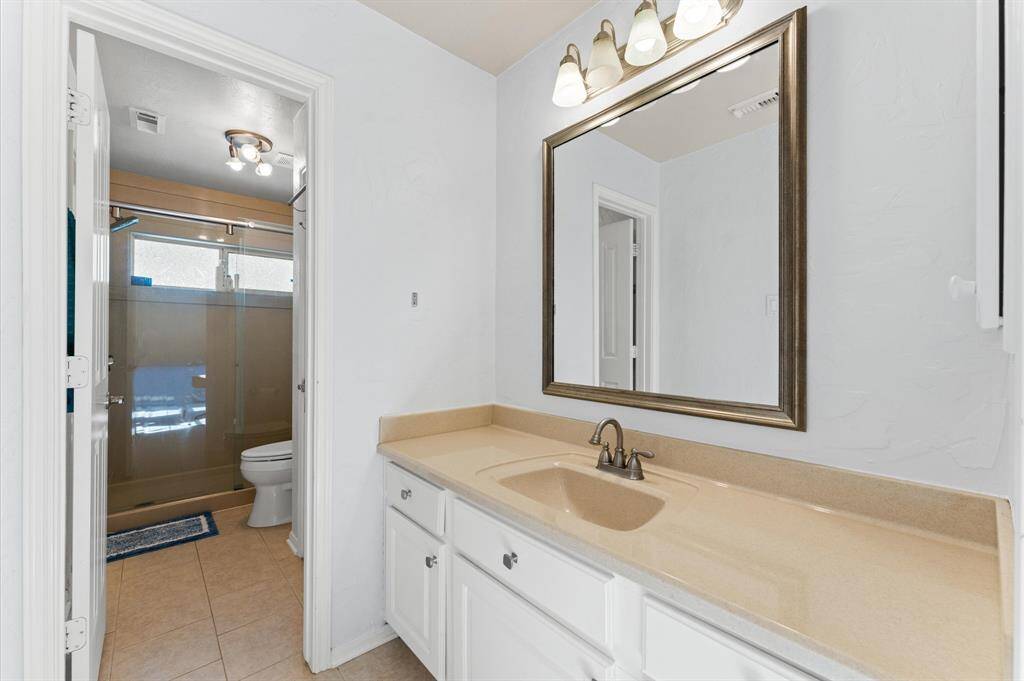 Elegant Jack and Jill bathroom featuring a spacious vanities and convenient dual access.