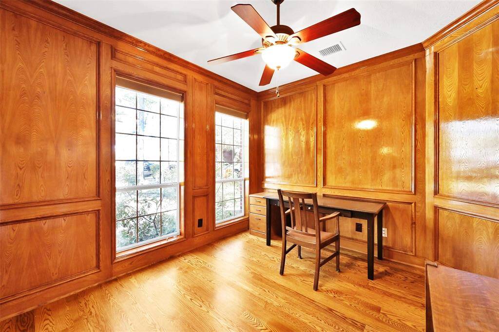 Elegant wood-paneled study with window french doors.