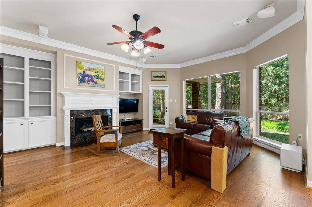 Inviting family room with built-ins, a cozy gas fireplace, and access to the covered patio.