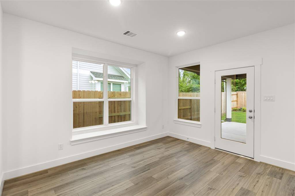 A charming nook off the dining space offers a cozy corner for morning coffee or reading, framed by expansive windows that flood the entire room with natural light.
