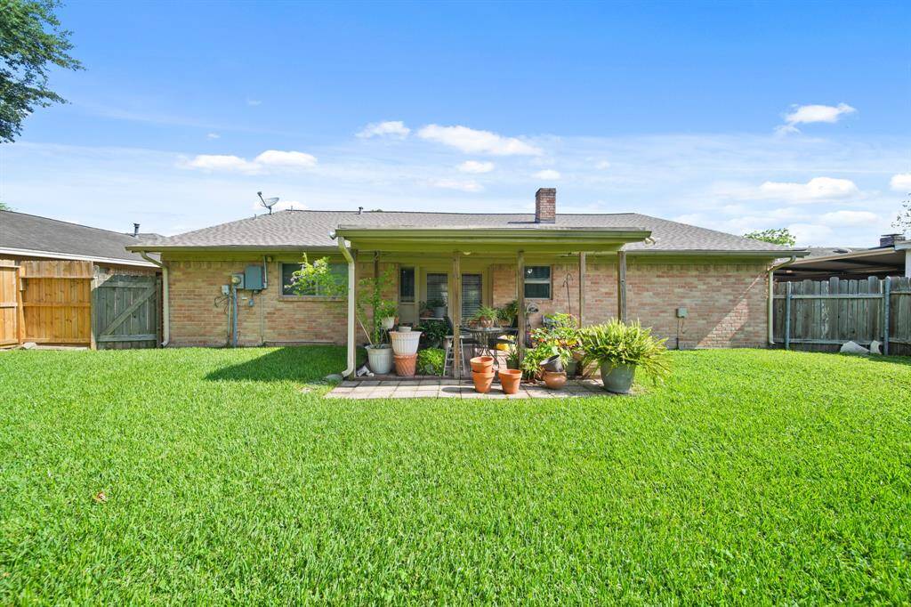 Large fully fenced in yard with a covered patio