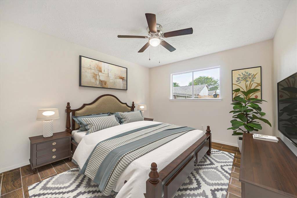 This photo is virtually staged. Wood look tile floors, 5 blade ceiling fan, fresh paint