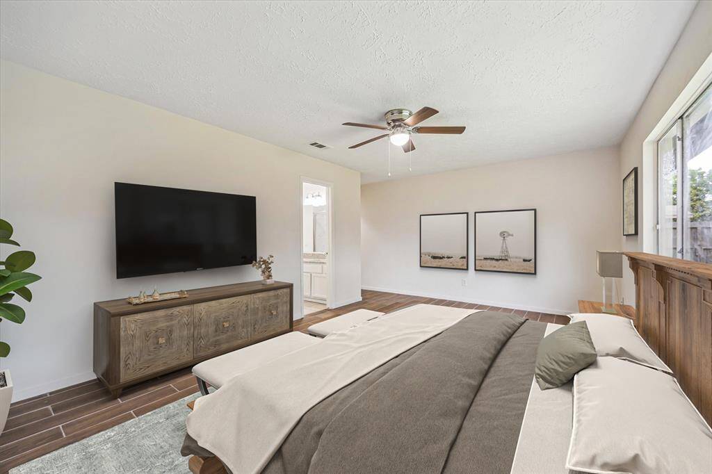 Photo is virtually staged. Wood look tile floors in the primary bedroom.