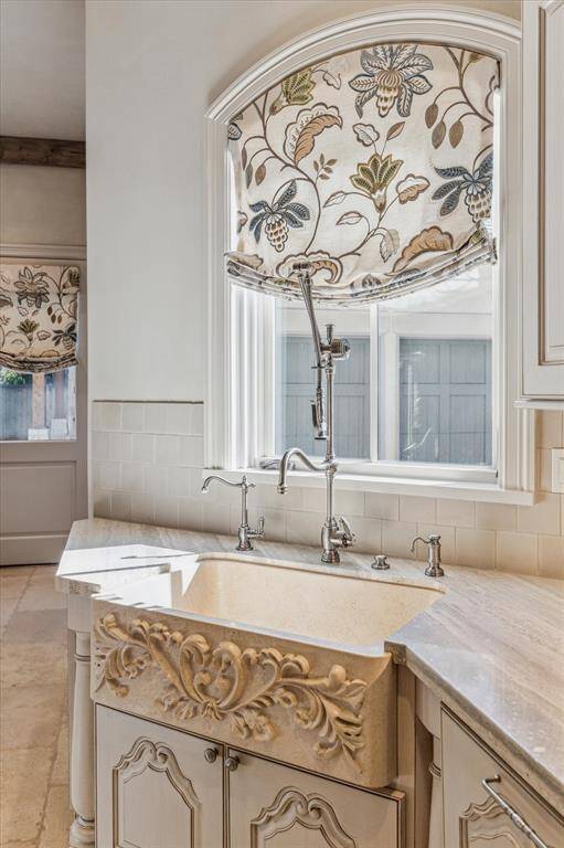 Carved stone sink with high end fixtures and hot water dispenser.