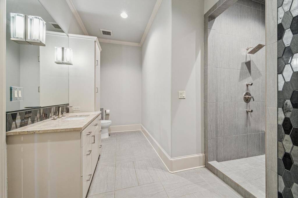 Secondary bath with stone countertop, large shower and quality finishes.