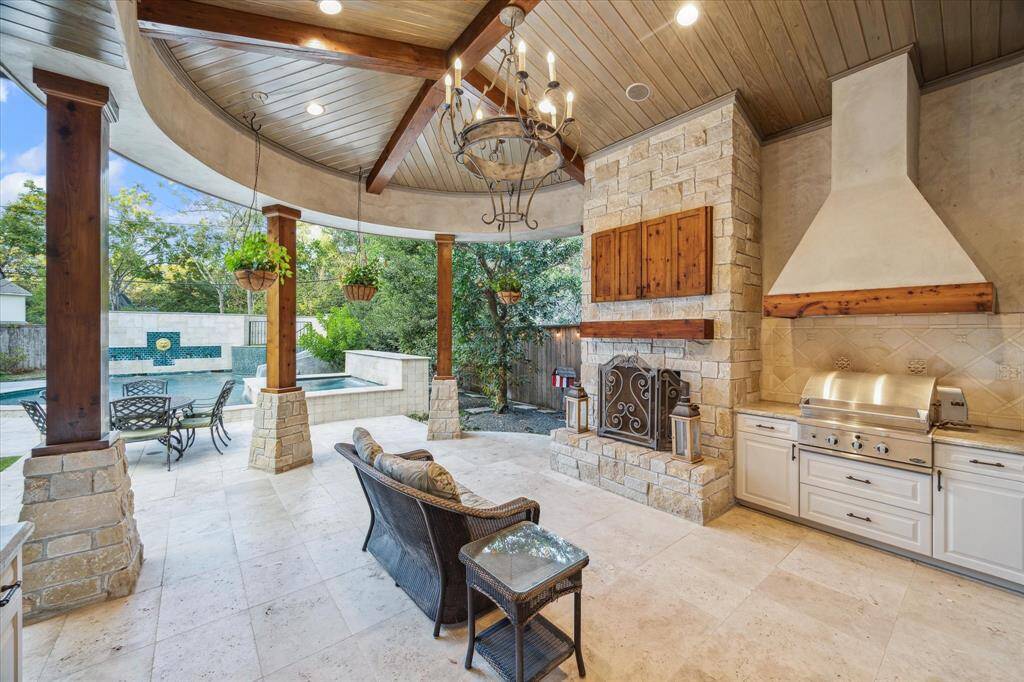 Summer kitchen complete with grill, fireplace and TV cabinet.