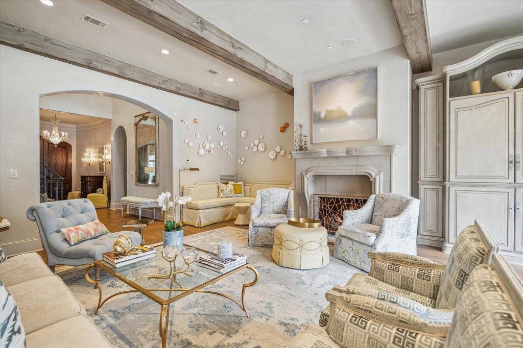 The family room features beamed ceiling, multiple sitting areas and built-in cabinetry.