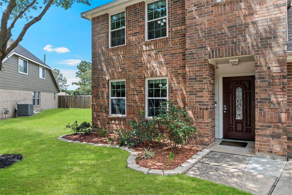 Charming brick home with a welcoming entrance, featuring a well-maintained lawn and landscaped garden beds. The front door is accentuated with decorative glass, offering a cozy and inviting curb appeal.