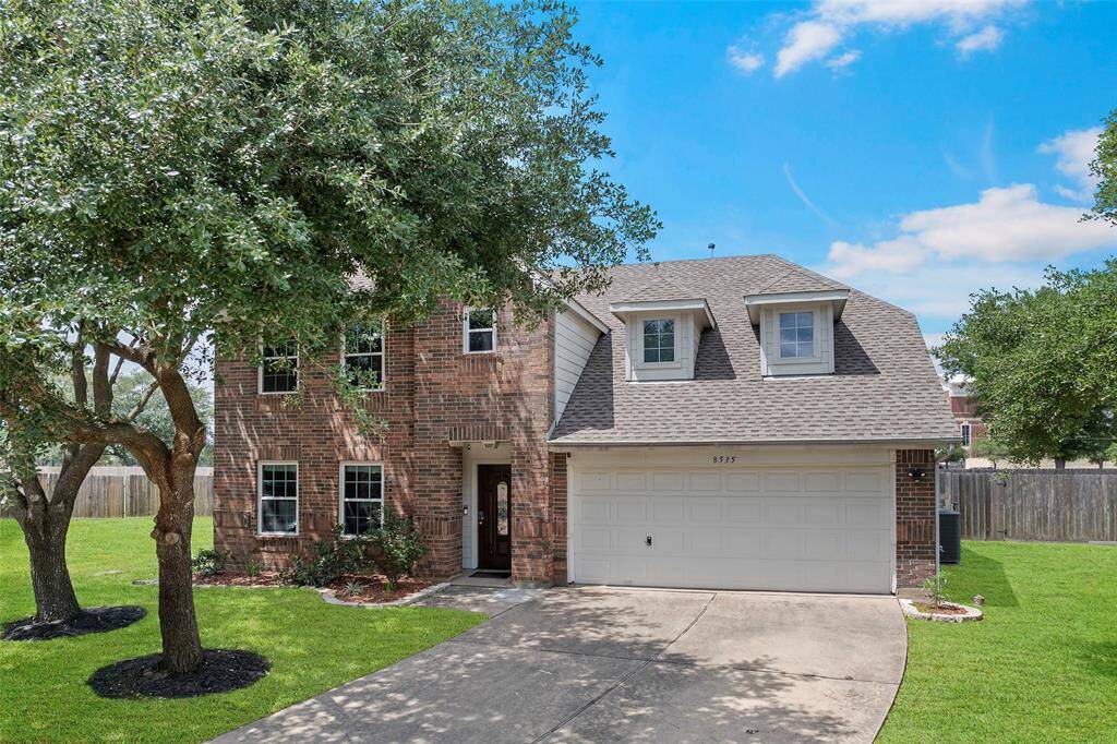Charming two-story brick home with a spacious front yard and mature trees. Features a double garage and a welcoming entrance, set in a serene neighborhood. Perfect for family living.