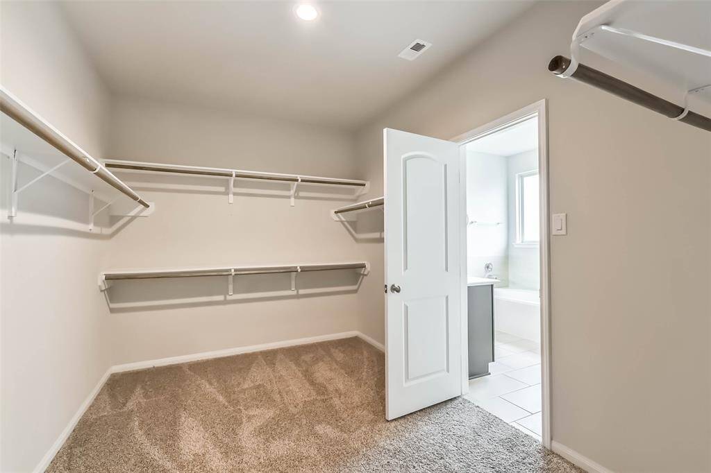 Master closet with door to utility room.