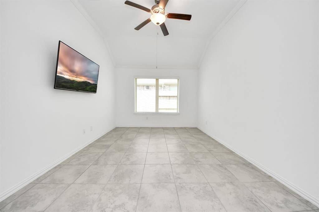 Bright and spacious office with high ceilings, a ceiling fan, and a large window for natural light. Ideal for remote work or study.