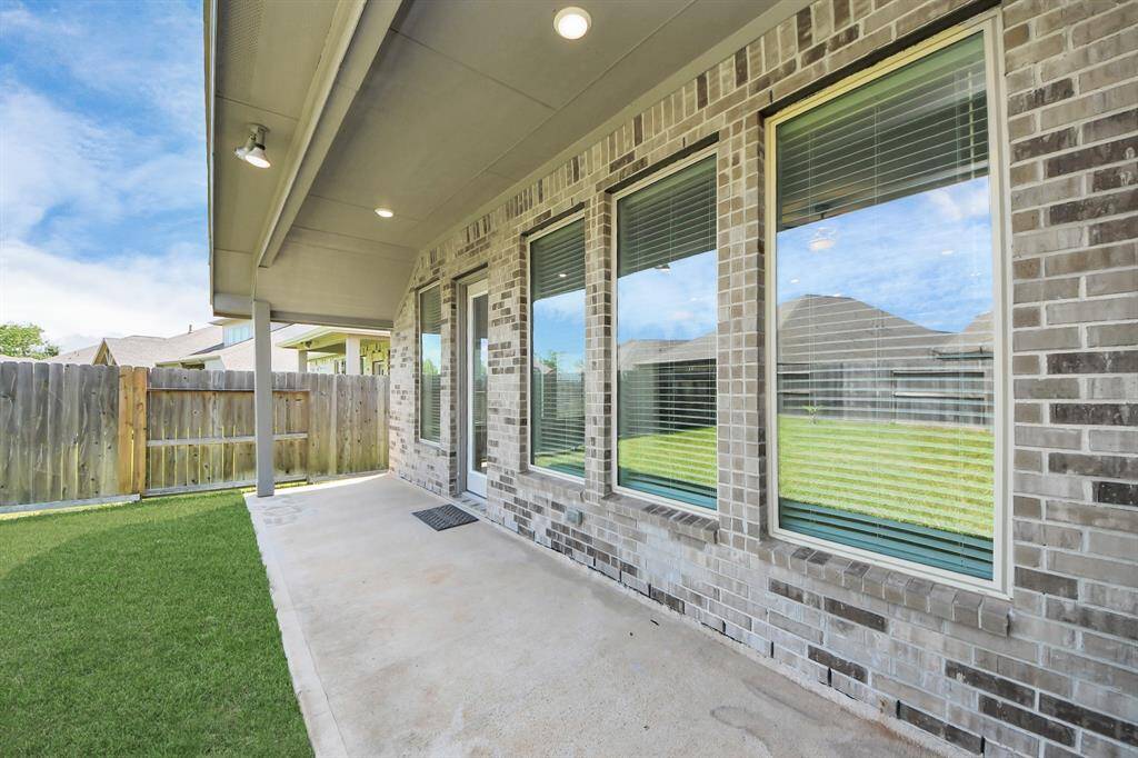 Spacious backyard with a large covered patio, perfect for outdoor relaxation and entertaining.