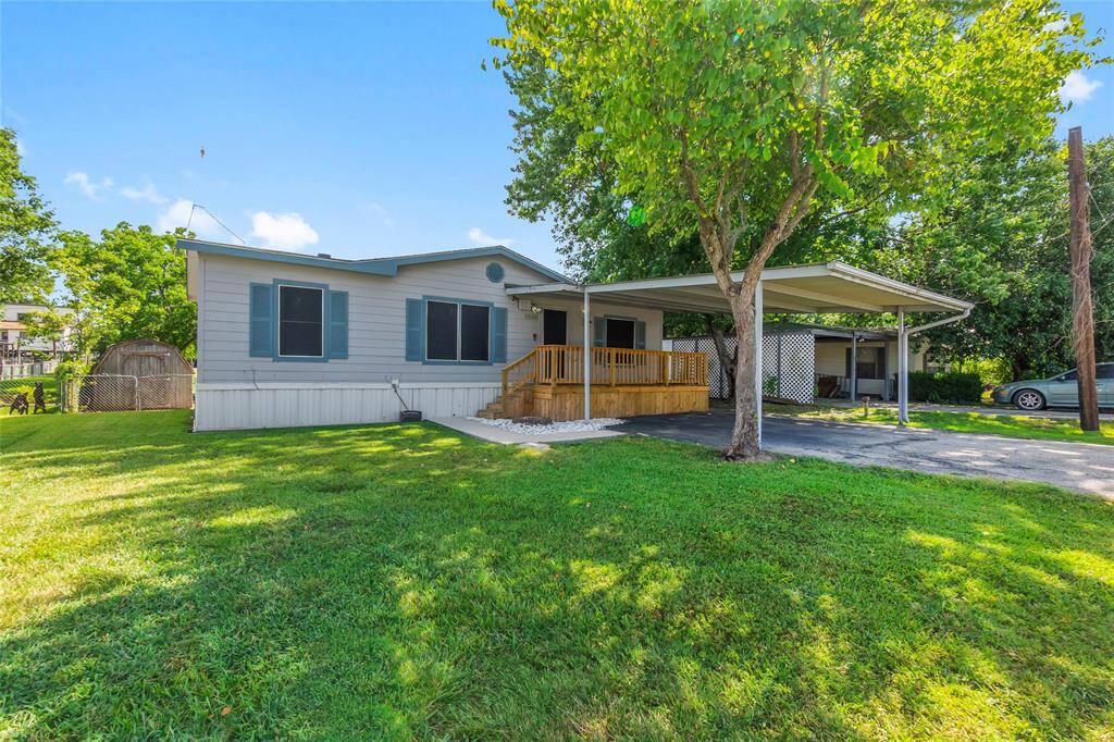 COVERED ATTACHED CARPORT WITH COVERED FRONT DECK OVERLOOKING BEAUTIFUL FRONT YARD